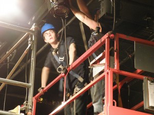 photo of two men working lights on a scaffold